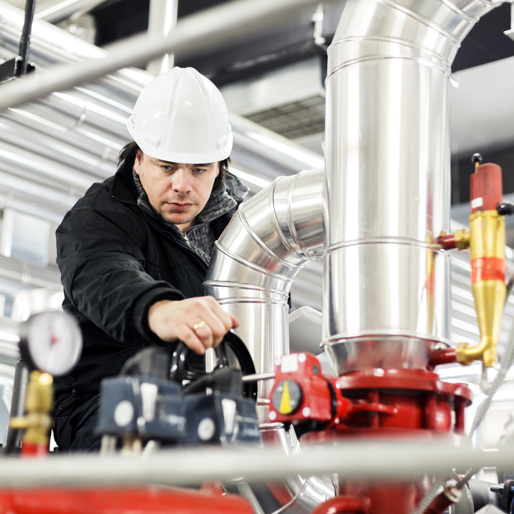 Engineer checking machinery gauges image