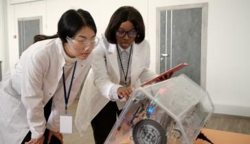 Women operating high tech lab equipment